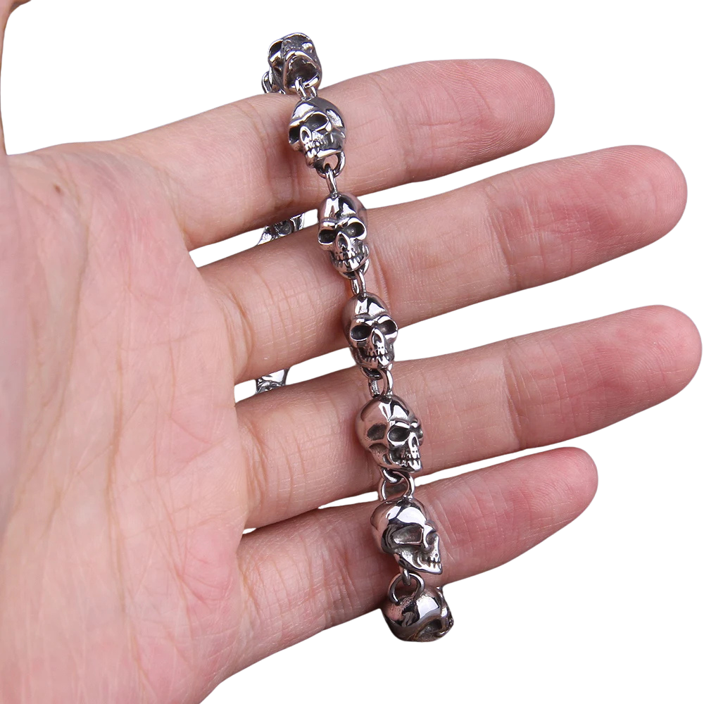 Silver skull bracelet on a hand against a white background