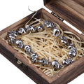 Silver bracelet with leaf designs in a wooden box with straw-like filler