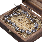 Silver bracelet with leaf designs in a wooden box with straw-like filler